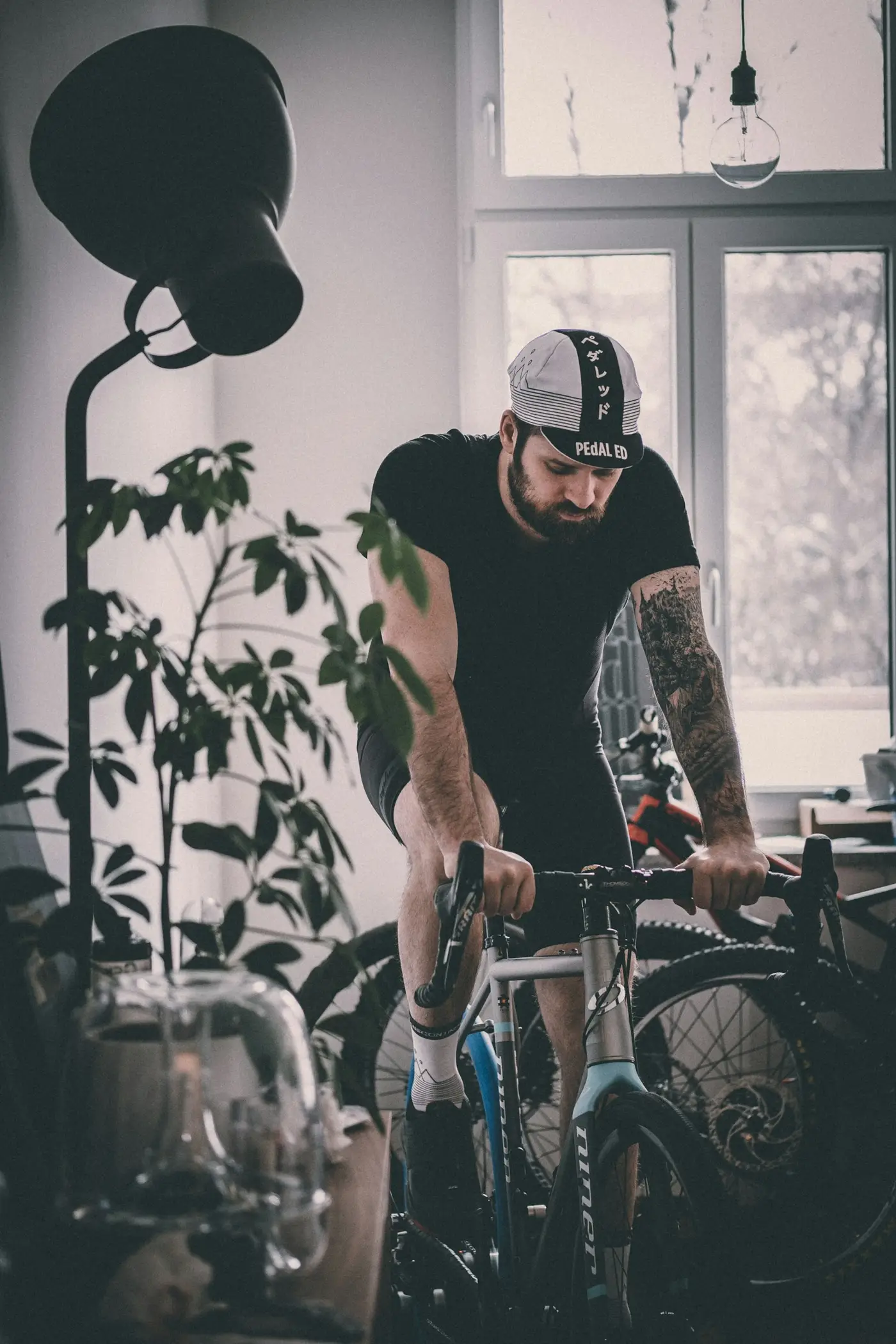 Mann auf Rennrad auf der Rolle, zu Hause am Fenster